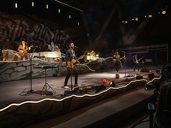 Close-up shot of Lord Huron guitarist Tom Renaud performing energetically on stage at Red Rocks Amphitheater.