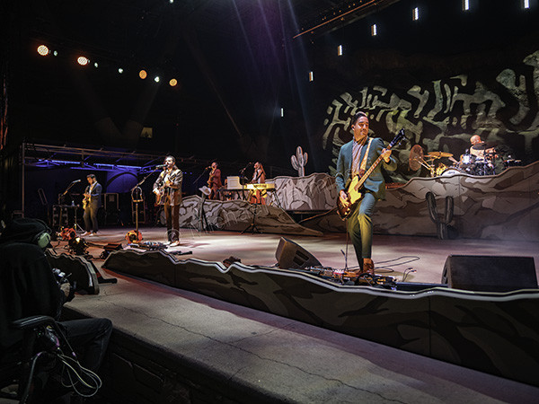 Lord Huron bassist Miguel Briseño performing with passion on the right side of the stage at Red Rocks concert.