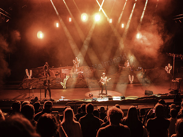 Ben Schneider as his alter ego Cobb Avery performing on stage, electrifying the Lord Huron crowd at Red Rocks.