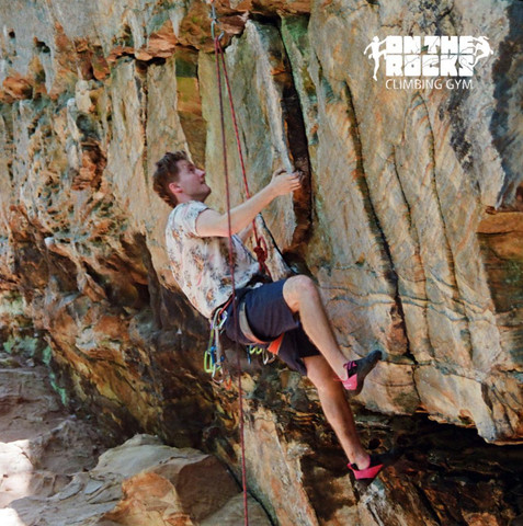 Lead climber being belayed outdoors on a rock face