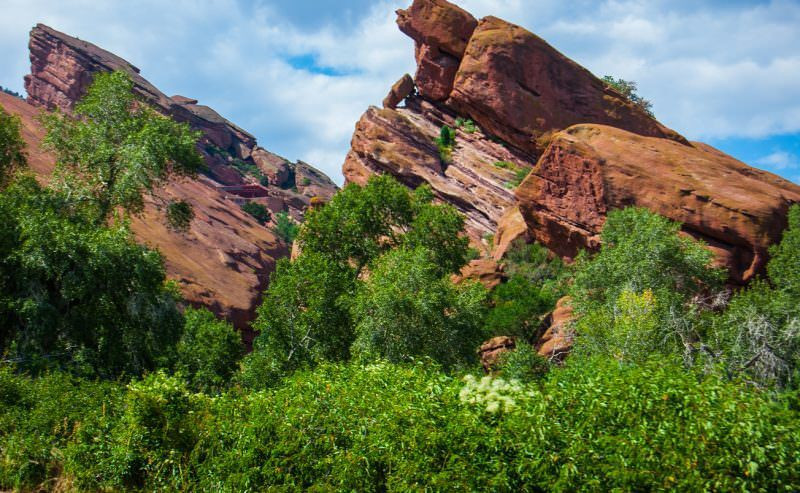 Denver skyline visible from Red Rocks Amphitheatre at dusk, highlighting the urban backdrop against the natural amphitheater setting.