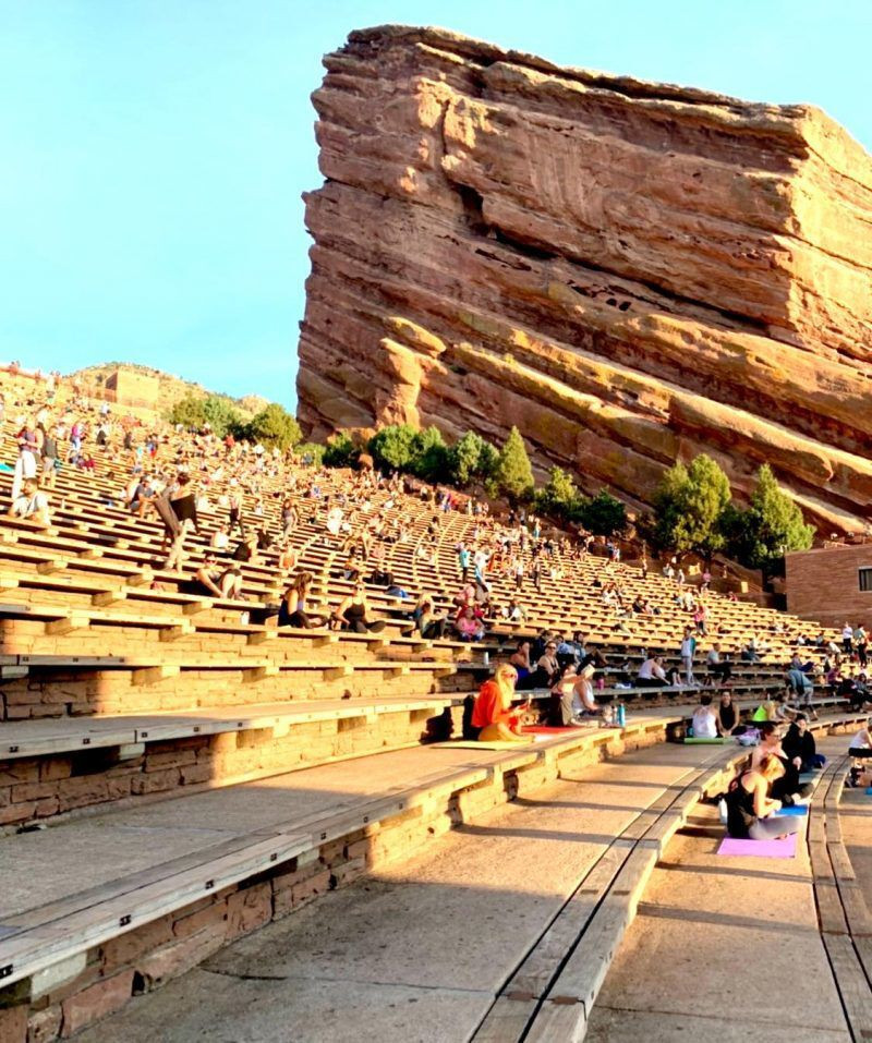 Large group participating in Yoga on the Rocks at Red Rocks Amphitheatre, emphasizing the popularity and unique experience of outdoor fitness events.