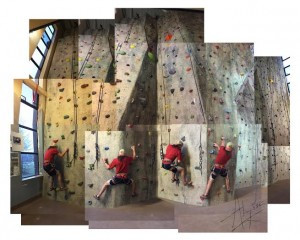 Enthusiastic climber ascending the vibrant 37-foot rock climbing wall at UMPI's Gentile Hall, showcasing the facility's exciting and accessible climbing experience.