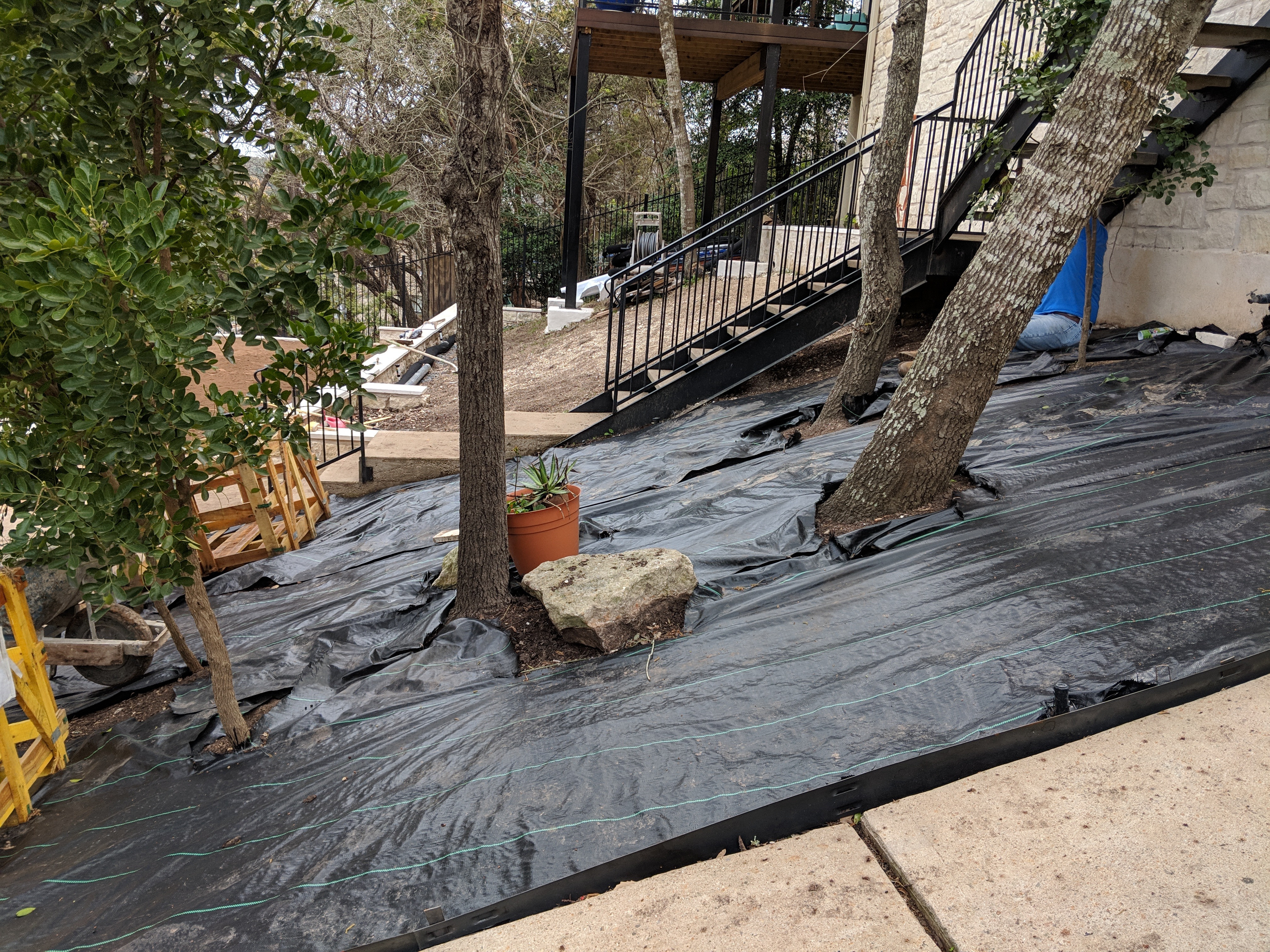 Landscape fabric used on a sloped garden bed, demonstrating appropriate material choice for hillside plantings and erosion control.