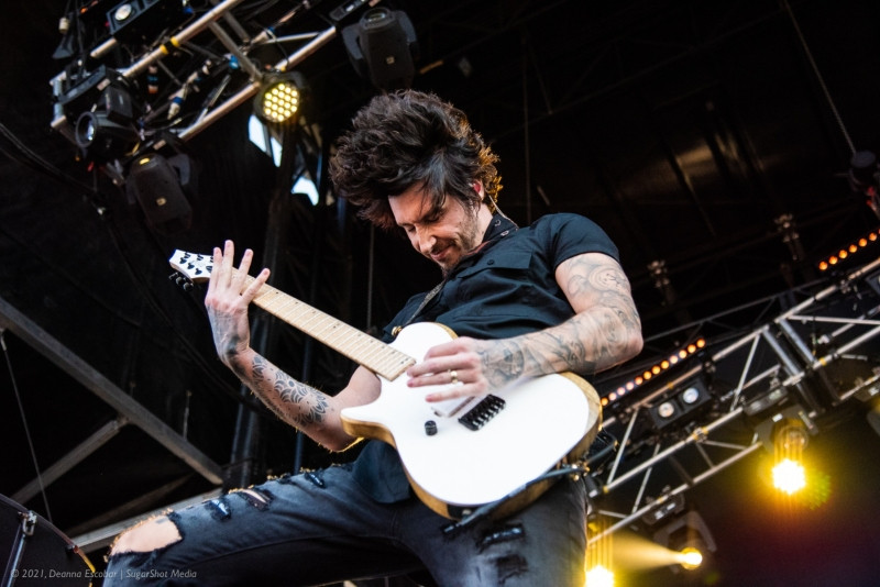 Cameron Liddell of Asking Alexandria playing guitar at Blue Ridge Rock Festival Day 2. The guitarist is focused on his performance, playing energetically on stage.