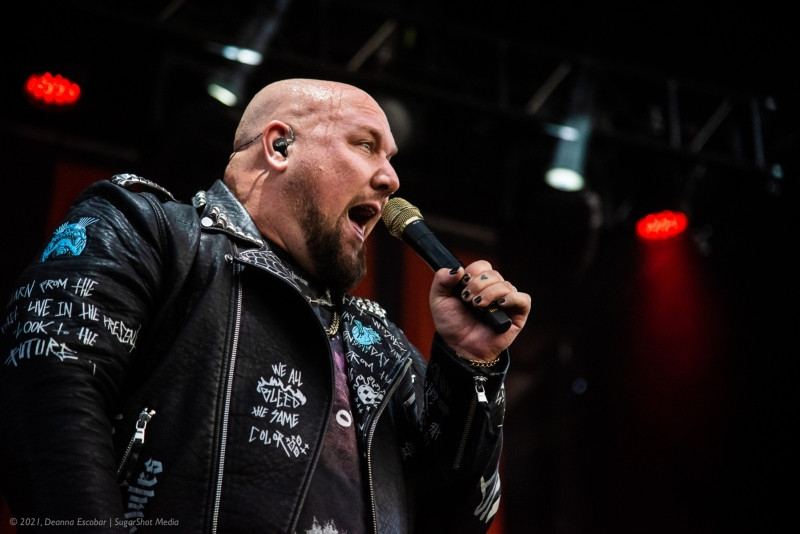 Brandon Saller of Atreyu performing drums and vocals at Blue Ridge Rock Festival Day 2. The musician is singing into a microphone while energetically playing the drums.