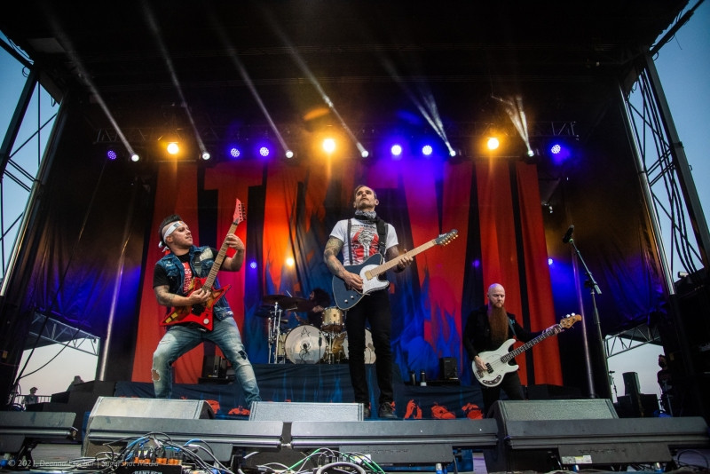 Dan Jacobs, Travis Miguel, and Marc McKnight of Atreyu performing at Blue Ridge Rock Festival Day 2. The Atreyu members are playing their instruments and interacting on stage.