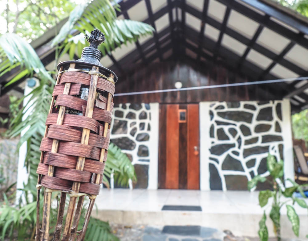 Illuminated tiki torch in front of a jungle cabin at Black Rock Lodge Belize