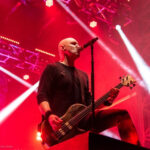 Breaking Benjamin's Aaron Bruch performing bass guitar at Blue Ridge Rock Festival Day 1. The bassist is headbanging and playing his instrument with energy.