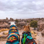 Two pit bull dogs in fleece sweaters admire the towering rock formations while camping at City of Rocks State Park, New Mexico