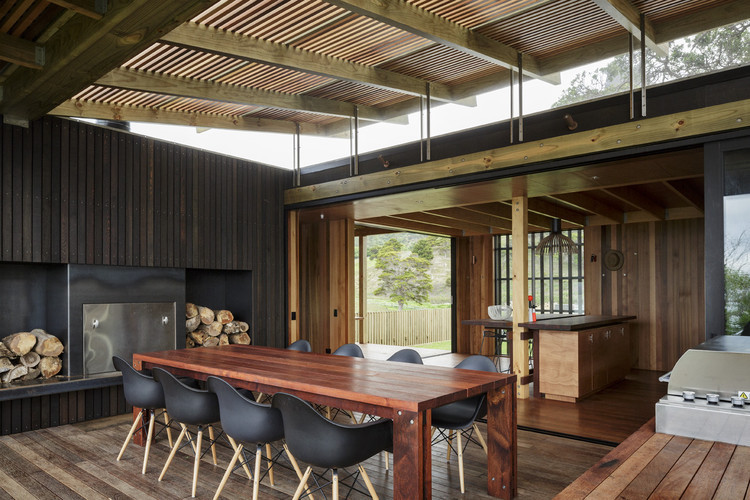 Interior dining area of Castle Rock Beach House featuring wooden table and chairs, emphasizing natural light and connection to outdoor views