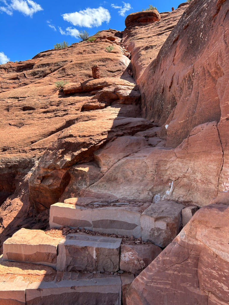 A hiker navigating a crack in the rock on Cathedral Rock Trail