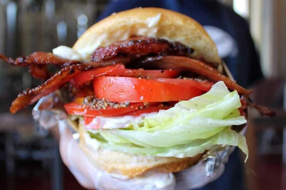 Close up of a mouthwatering burger from Cibi Cibi Restaurant in Rock Hill, known for its food truck fare