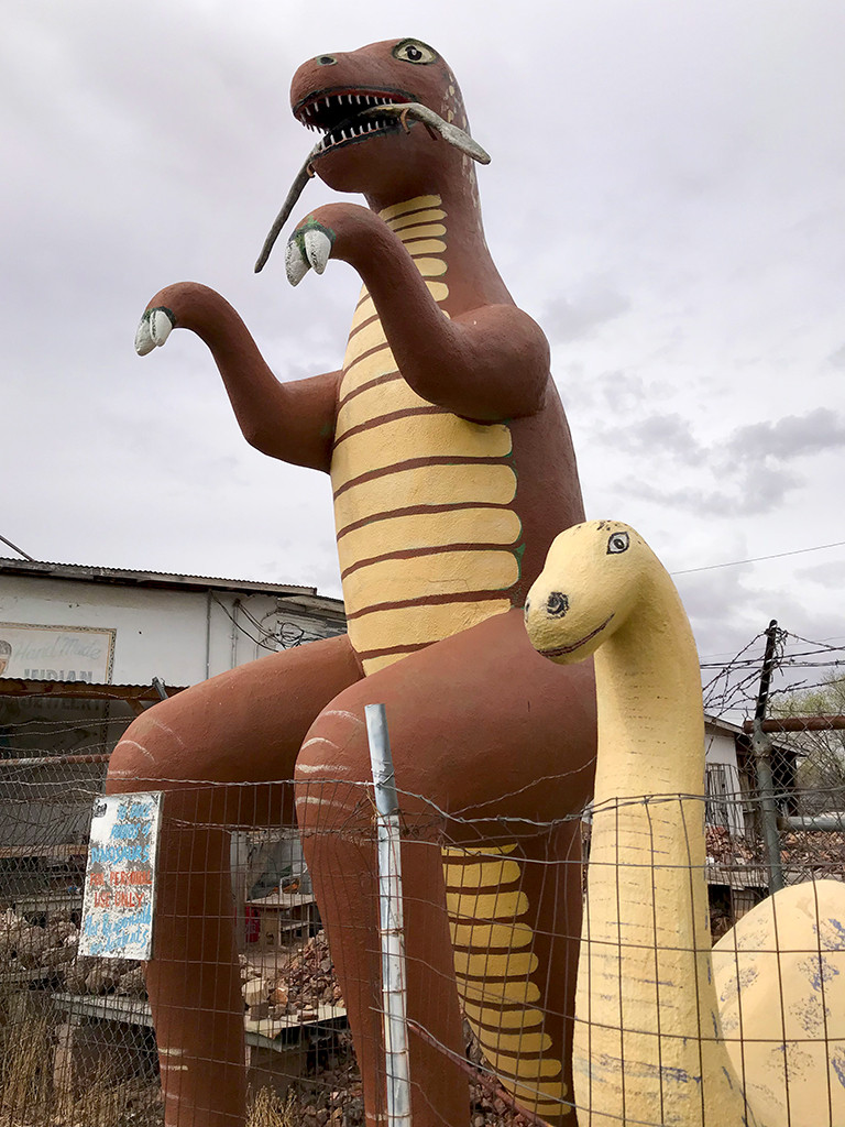 A vibrant image of multiple dinosaur statues at the Rainbow Rock Shop, emphasizing their role as a Holbrook landmark