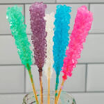 Close-up of 5 different colors rock candy in mason jar with