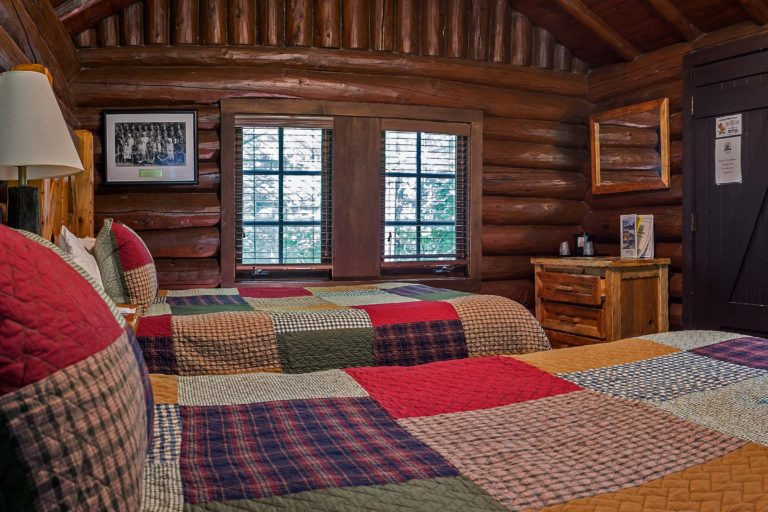 Interior of a Pioneer Cabin Double Queen room showcasing two queen beds and rustic decor