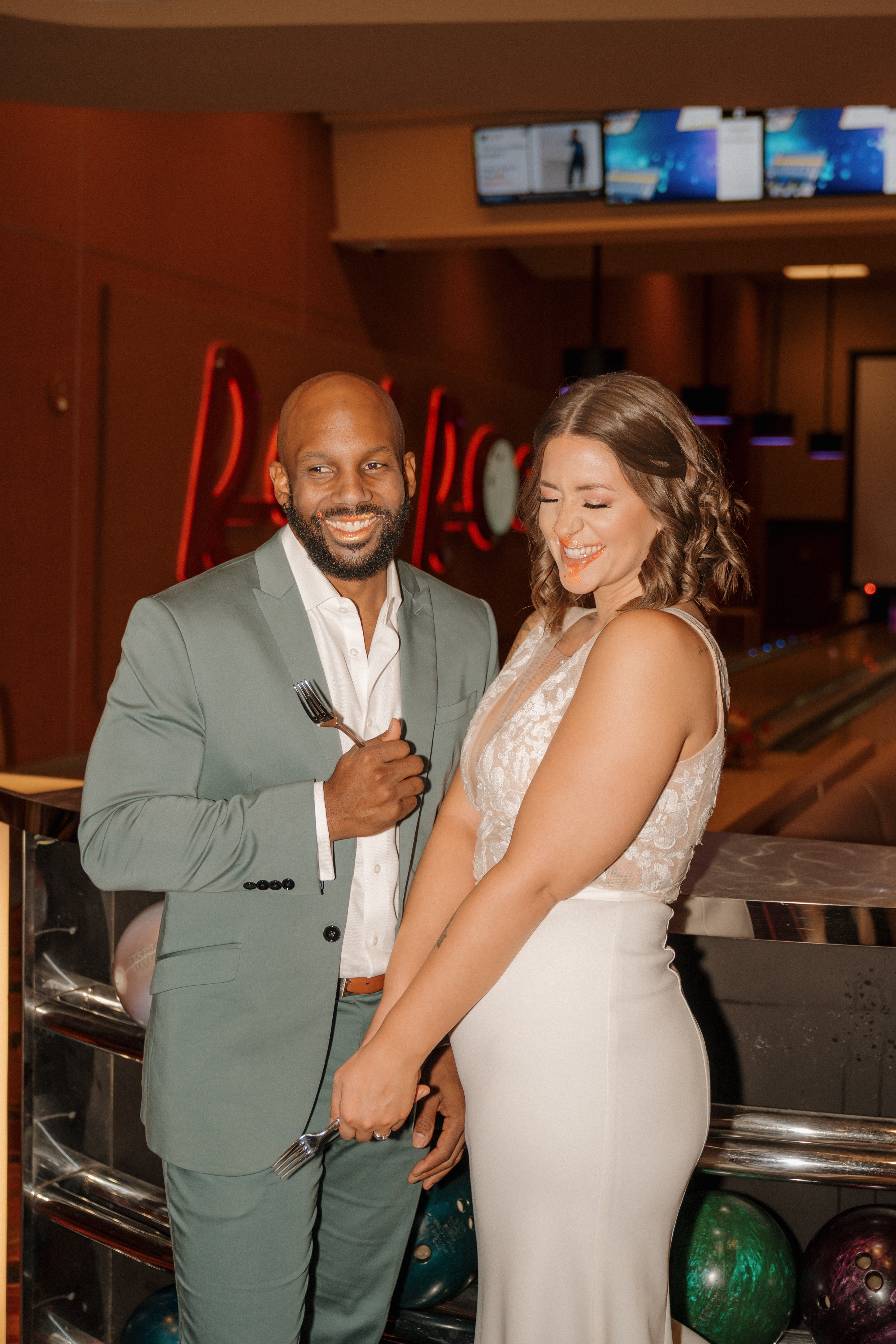 Bride and groom sharing pizza at their Red Rock Lanes bowling alley wedding