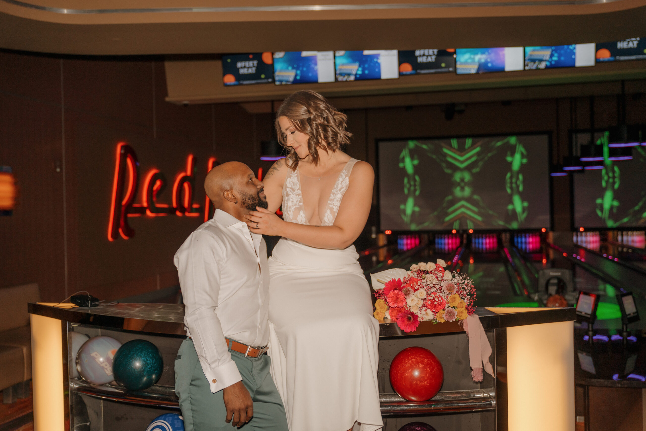 Bride and groom sitting on bowling lane and posing at Red Rock Lanes