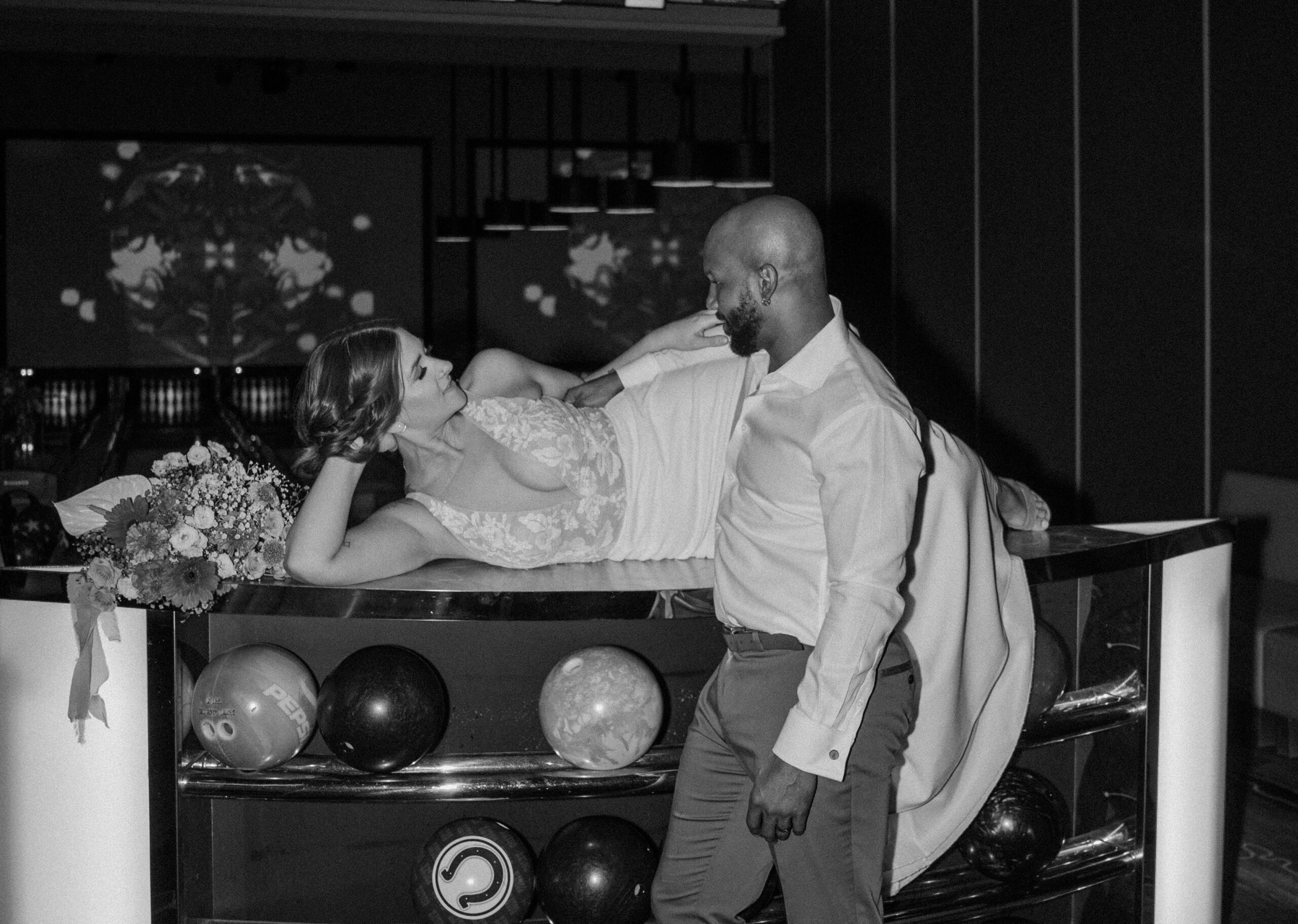 Bride and groom laughing and posing on bowling lane at Red Rock Lanes