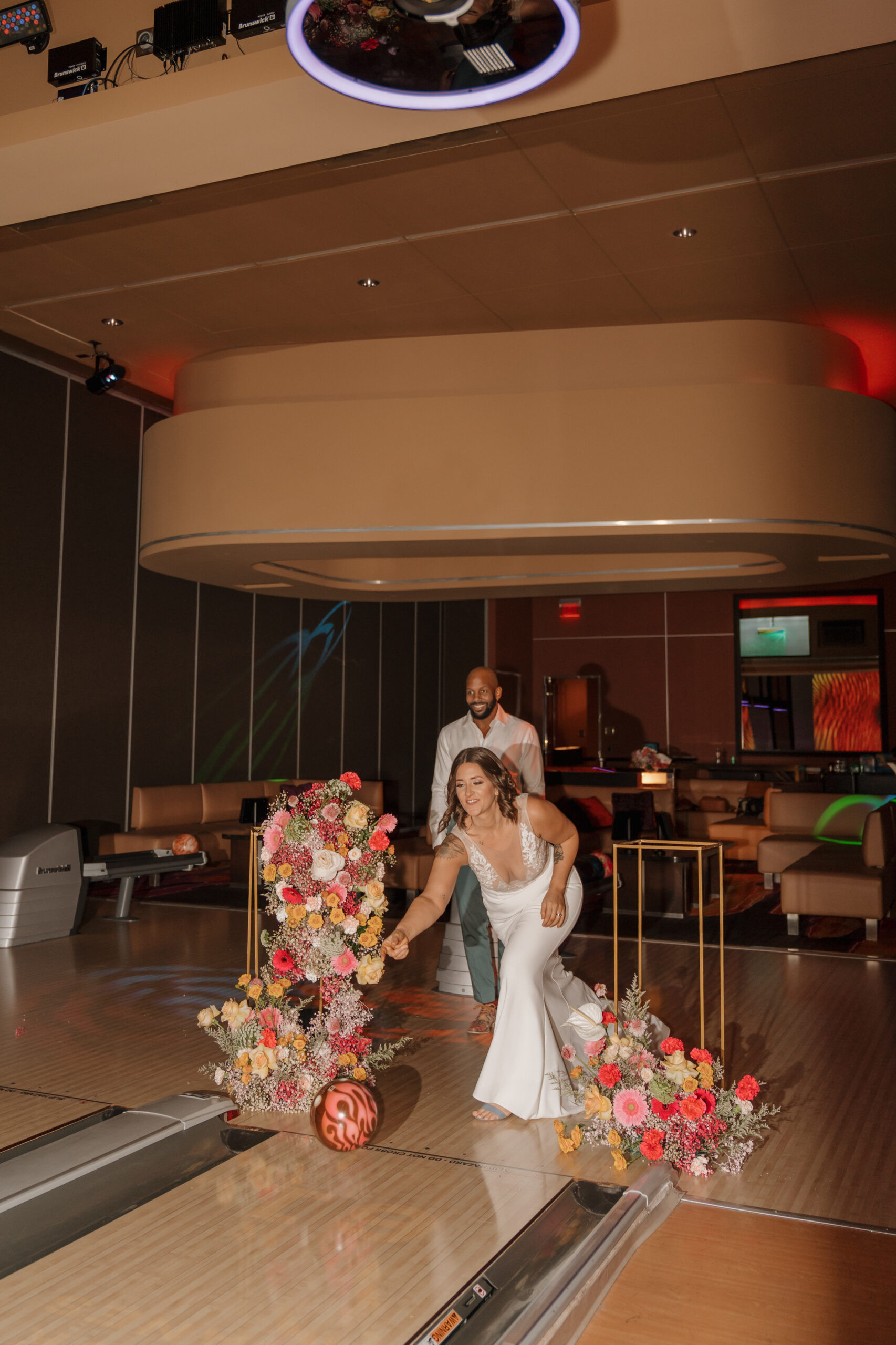 Bride and groom posing with bowling ball and pins at Red Rock Lanes