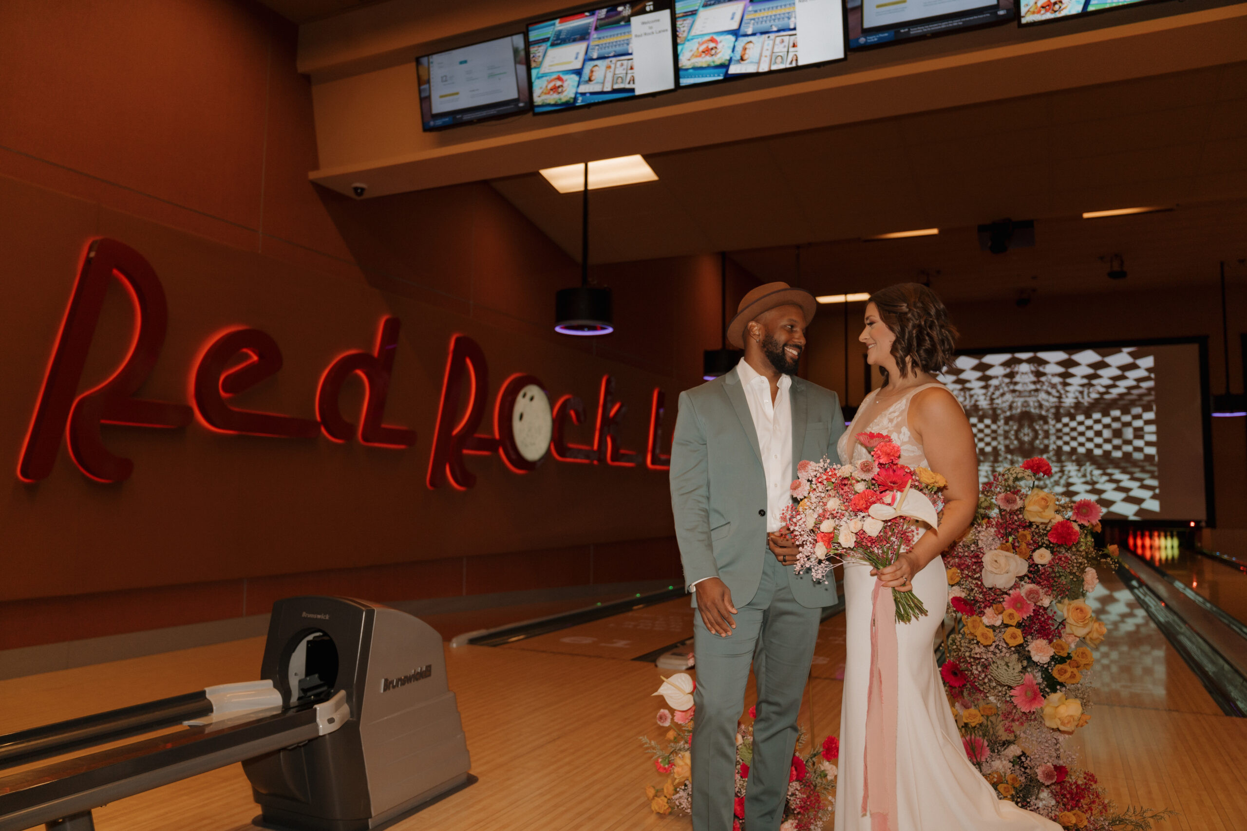 Eloping couple sharing a kiss at Red Rock Lanes during bowling alley wedding