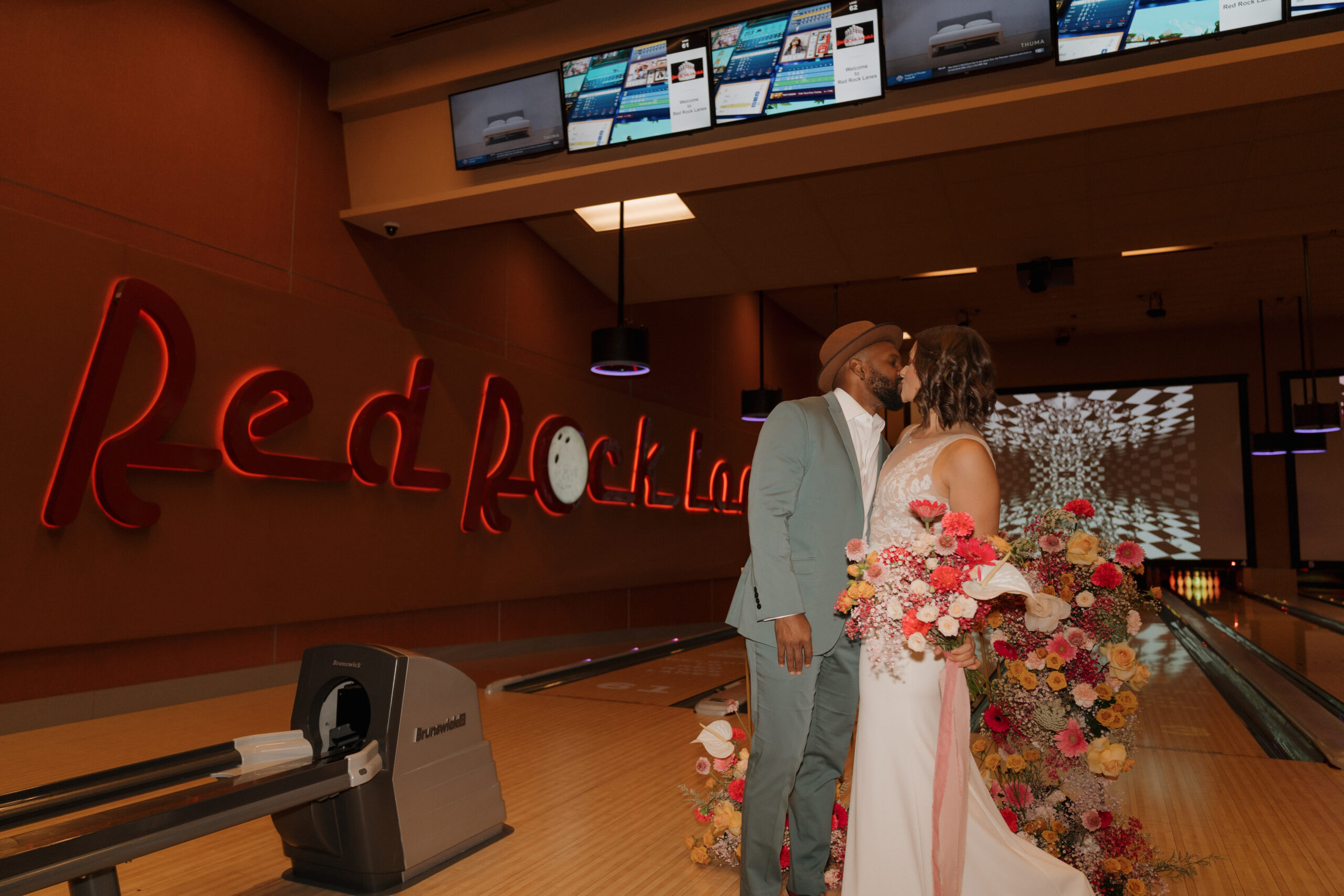 Bride holding floral bouquet at Red Rock Lanes bowling alley wedding reception