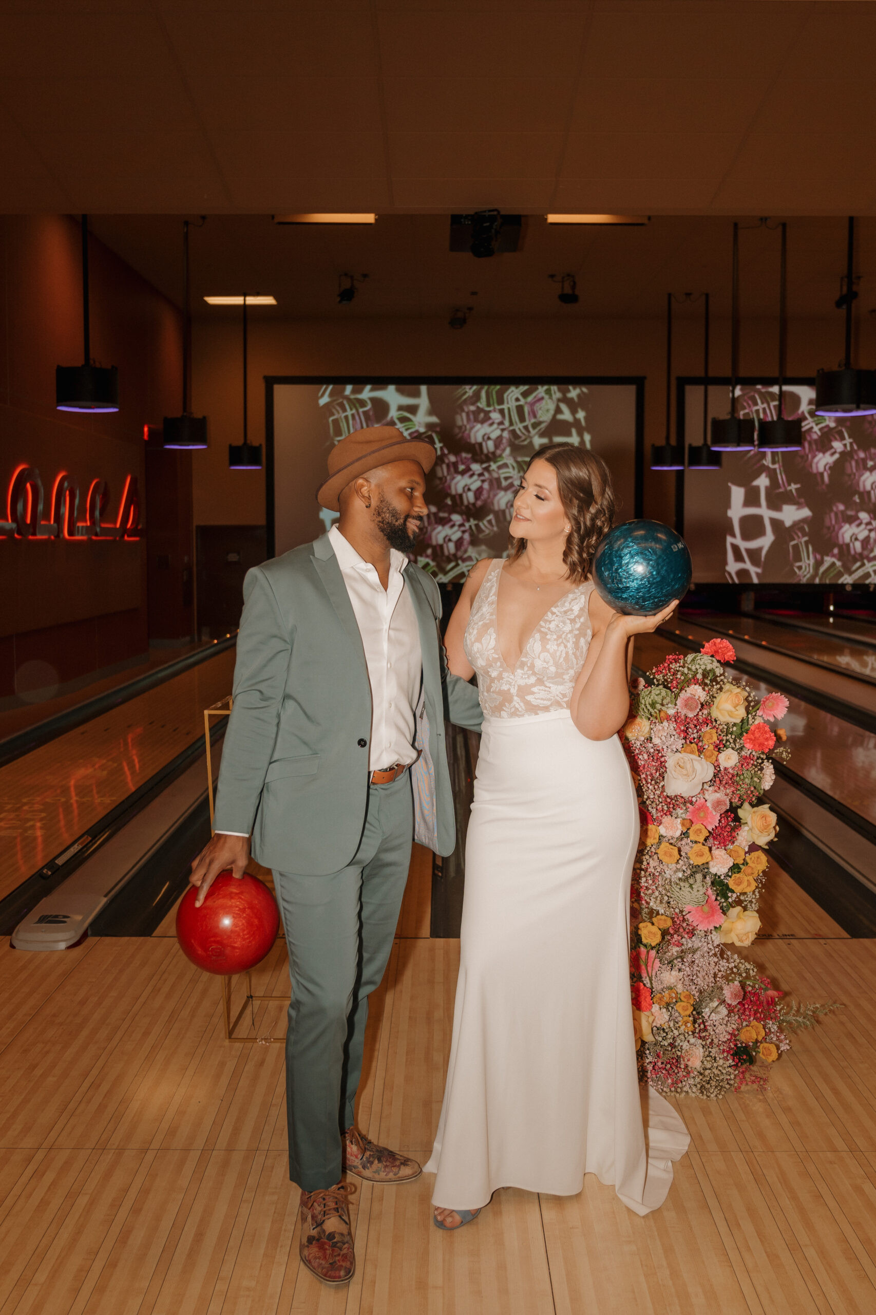 Bride and groom posing in front of bowling lanes at Red Rock Lanes elopement