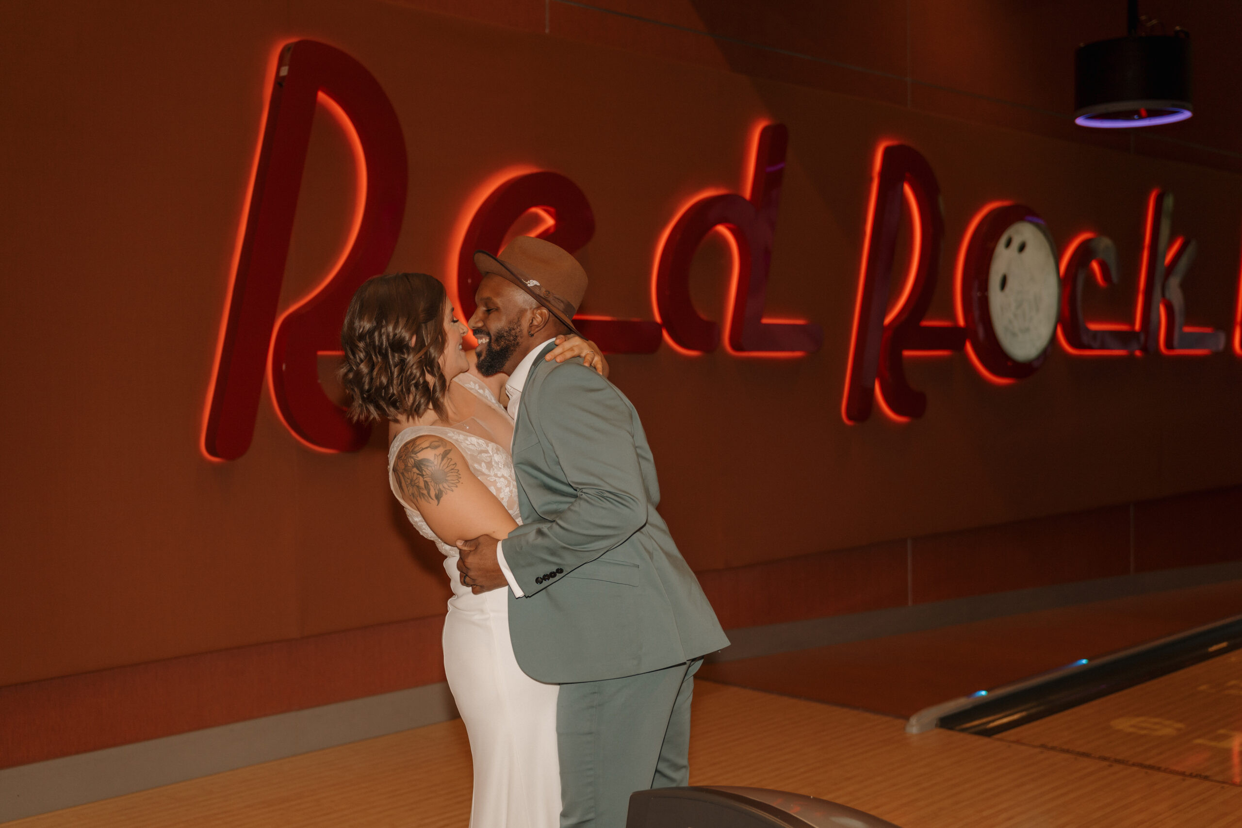 Bride and groom posing in front of bowling lane numbers at Red Rock Lanes elopement