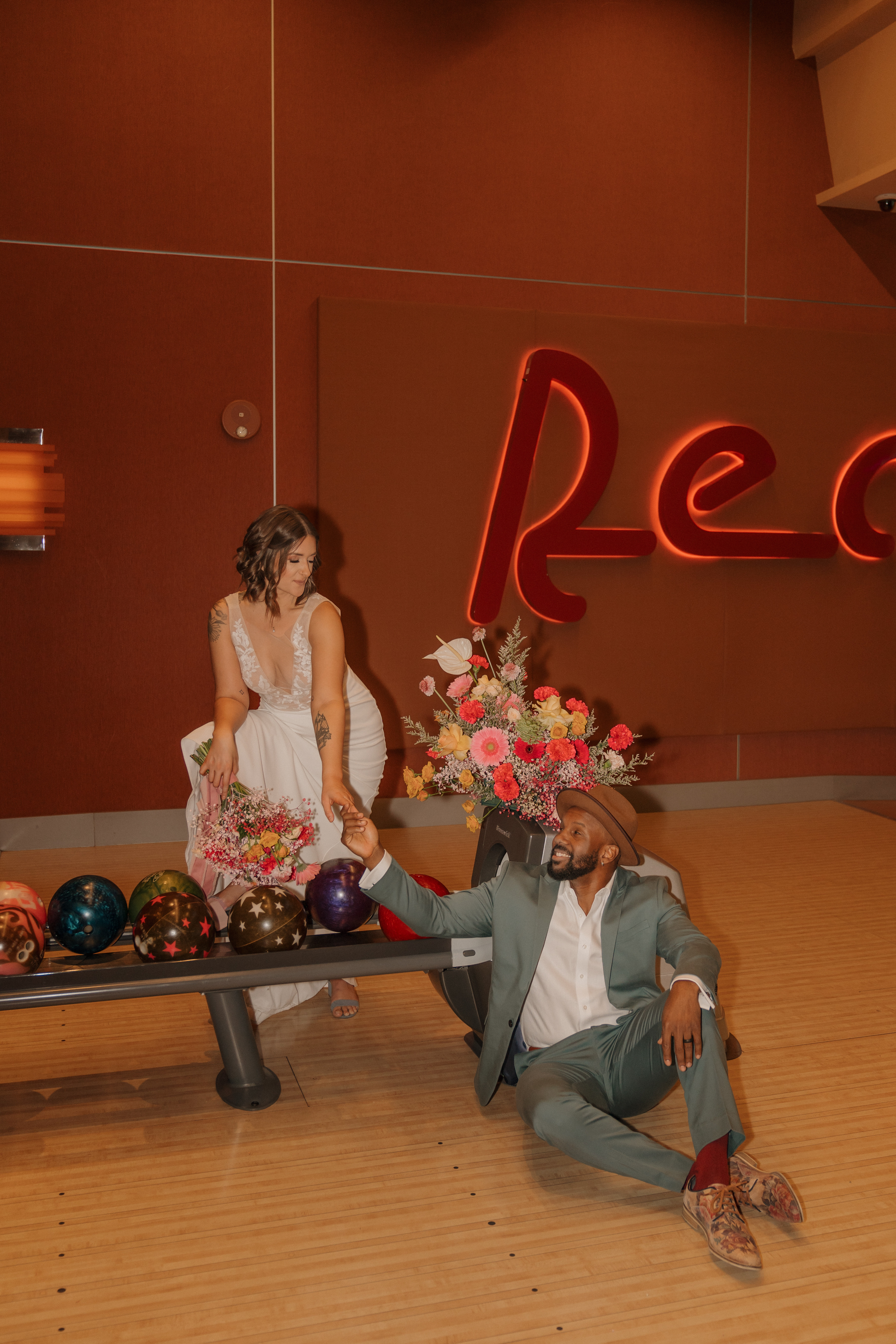 Bride and groom hugging and laughing at arcade games in Red Rock Lanes