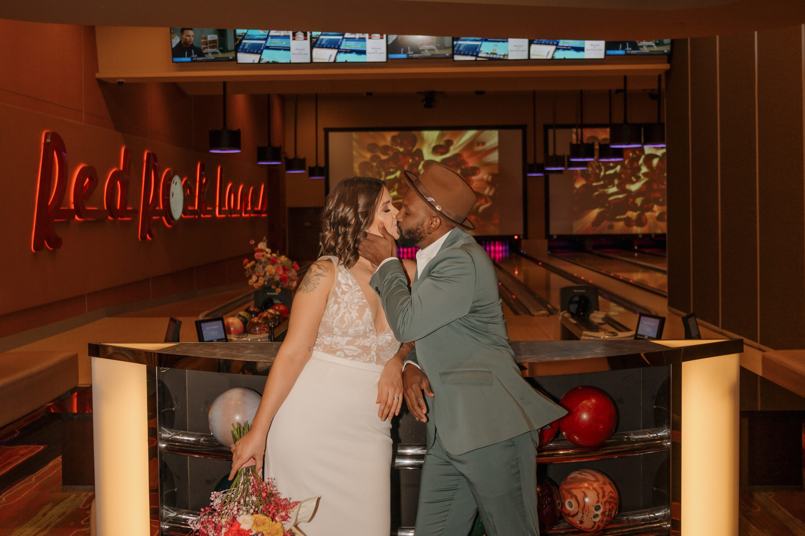 Bride and groom posing with arcade game prizes at Red Rock Lanes