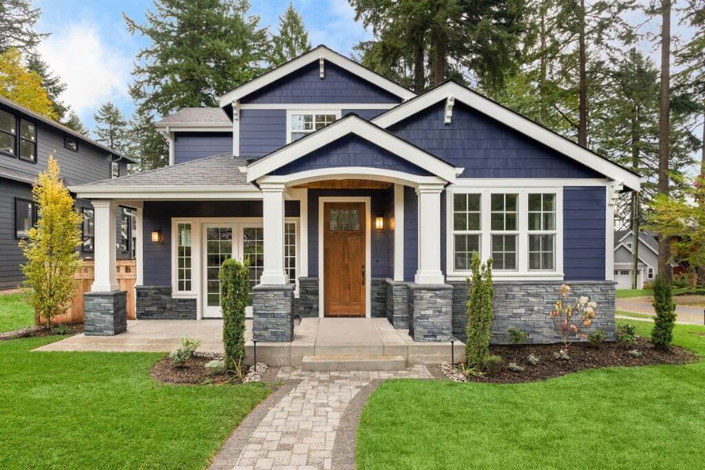 A person installing fake rock siding on a house