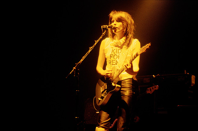 Chrissie Hynde of Pretenders performing with guitar, alt text: Chrissie Hynde of The Pretenders, rock icon, delivers a timeless performance with her signature guitar style.