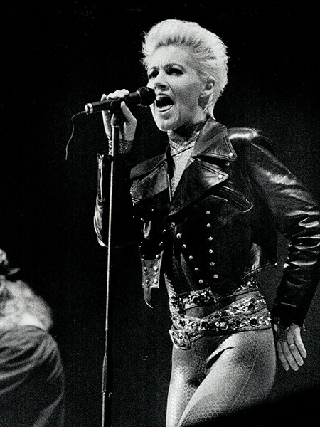 Marie Fredriksson of Roxette performing live, alt text: Marie Fredriksson, the voice of Roxette, belts out a power ballad during a vibrant live show.