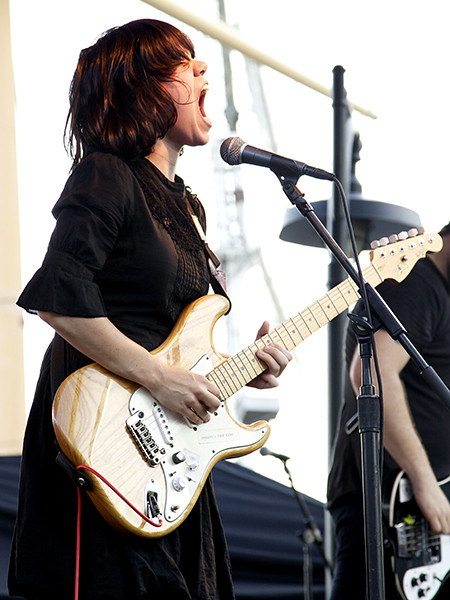 Marissa Paternoster of Screaming Females performing guitar, alt text: Marissa Paternoster of Screaming Females, indie rock guitarist and vocalist, shreds on stage with raw energy.