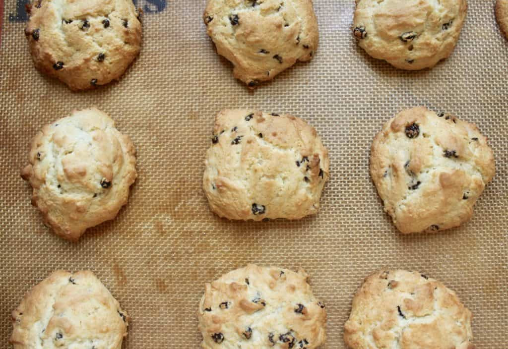 Rustic rock cakes or rock buns displayed on a cooling rack, highlighting their traditional, uneven shapes and currant inclusions