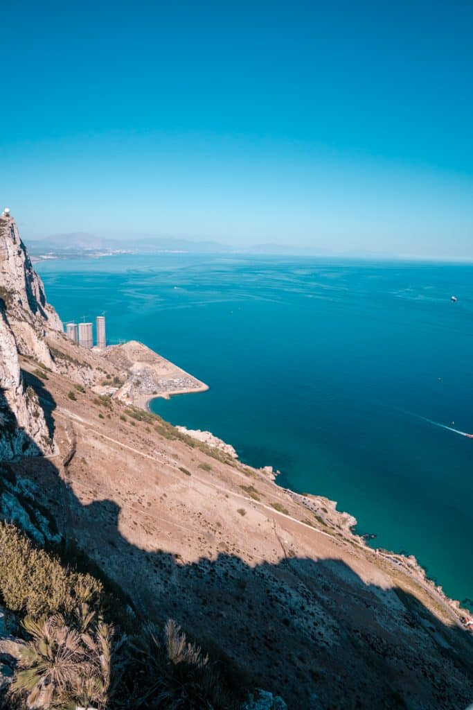 Historical depiction of a siege of Gibraltar, showing naval ships firing cannons at the rock and land-based fortifications.