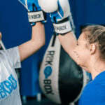 Two happy RockBox members congratulating each other during a kickboxing workout