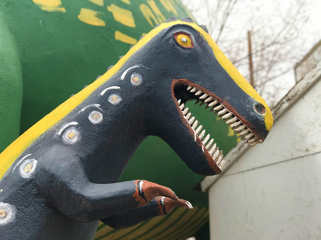 A group of dinosaur statues at the Rainbow Rock Shop in Holbrook, Arizona, capturing the playful and nostalgic atmosphere