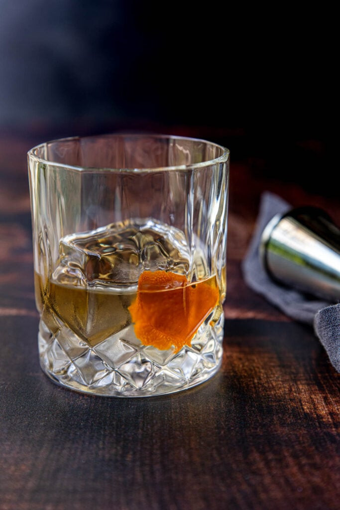 Añejo tequila on the rocks with an orange coin, a classic garnish.