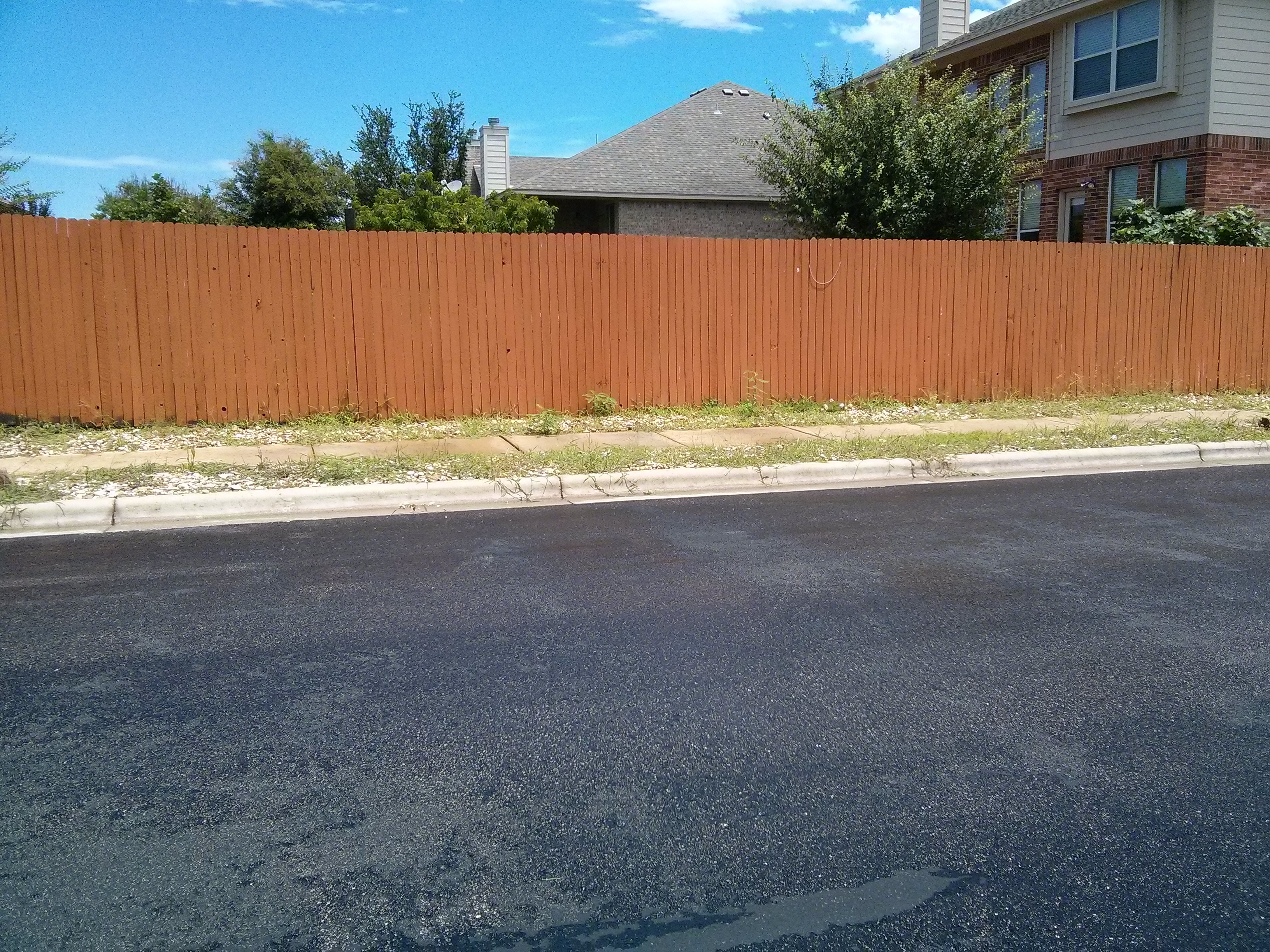 Example of a neglected rock landscape overrun with weeds, highlighting the need for regular maintenance.