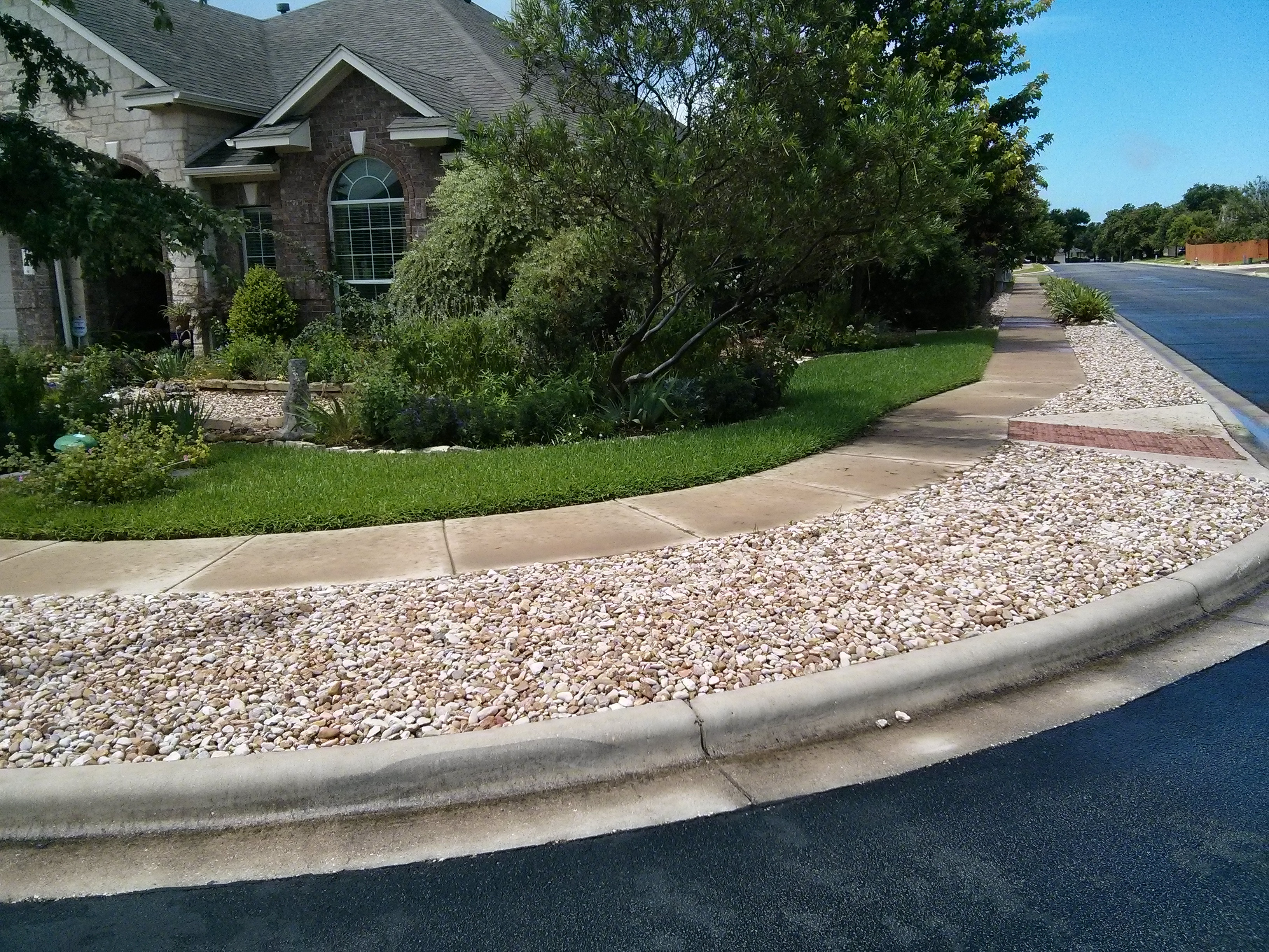 River rock landscaping with defined border, showcasing clean lines and contained rock placement.