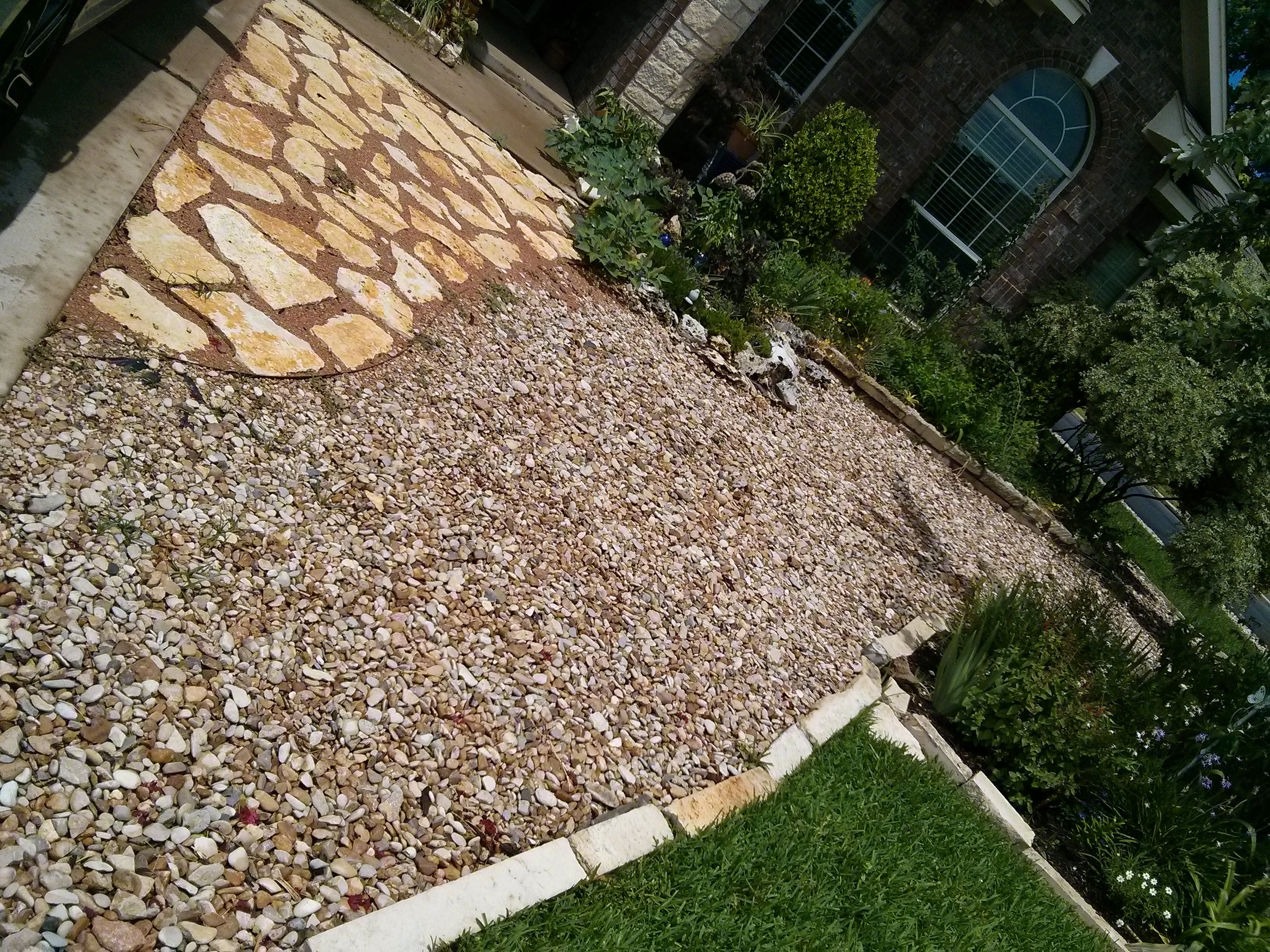 River rock pathway with stepping stones, demonstrating a practical and attractive solution for garden walkways and drainage.