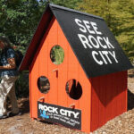 Iconic "See Rock City" birdhouse perched amongst natural foliage