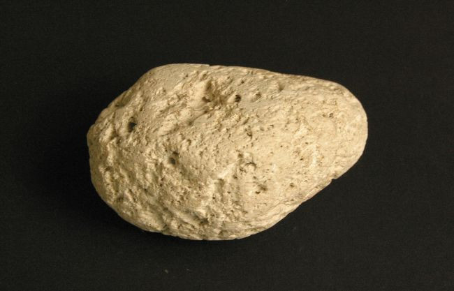 Lightweight pumice stone showing its porous texture and numerous gas bubbles.