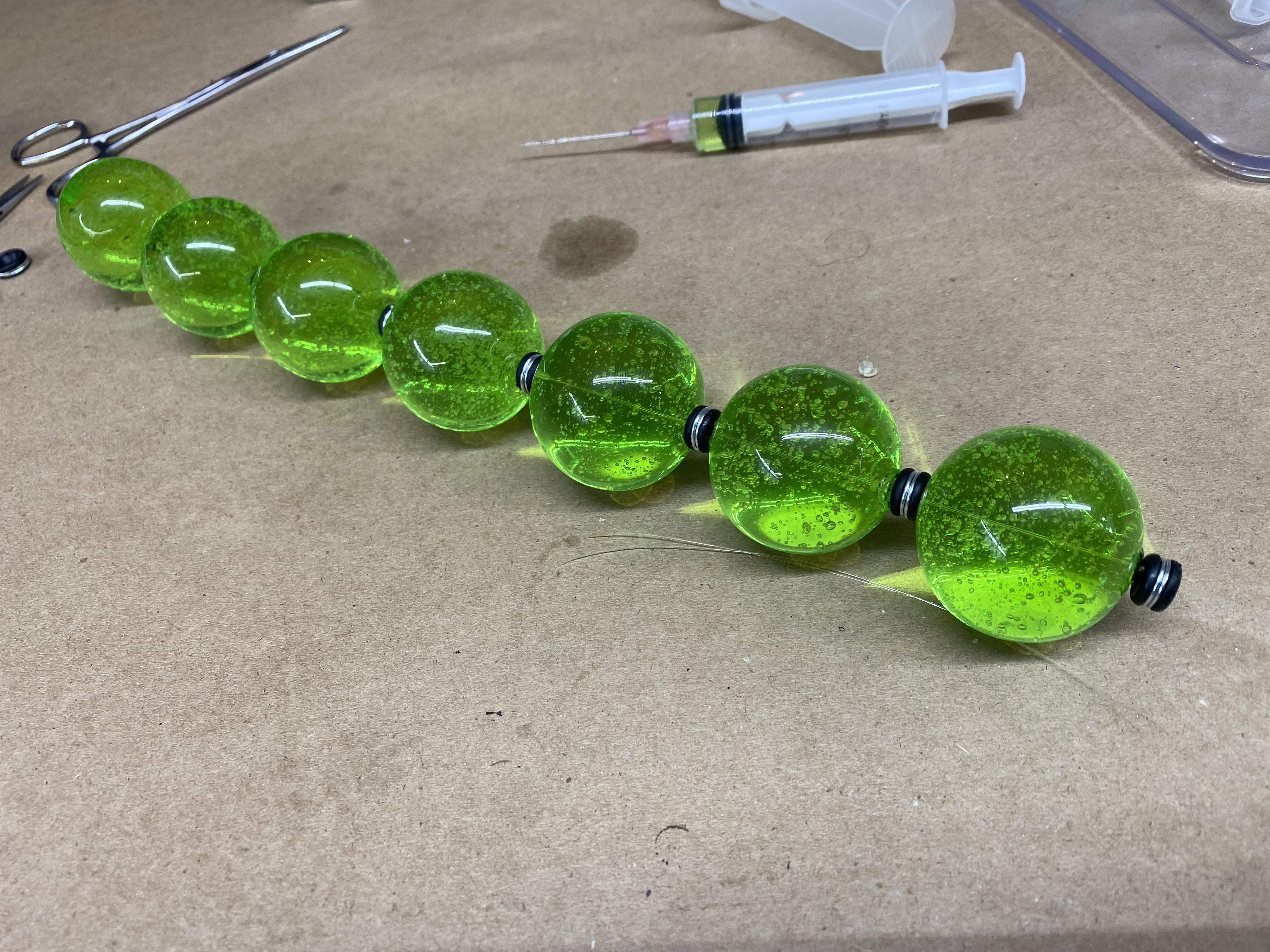 Threading filled glass pearls and spacers onto monofilament line for VX canister prop replica