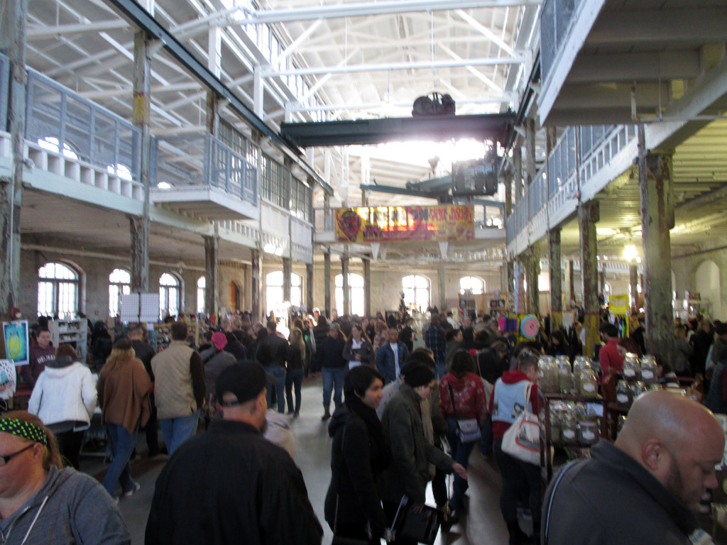 The interior of the Roebling Wire Works during the Trenton Punk Rock Flea Market, showing vendors and attendees.