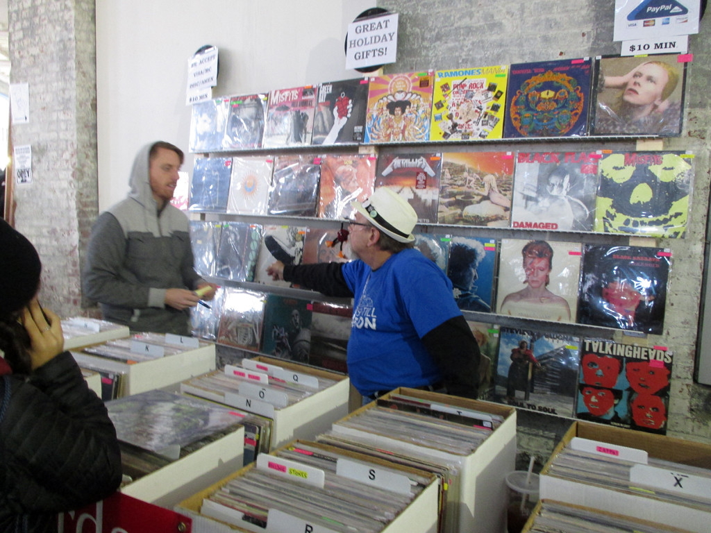 A vendor stall displaying a large selection of vinyl records, including David Bowie albums.