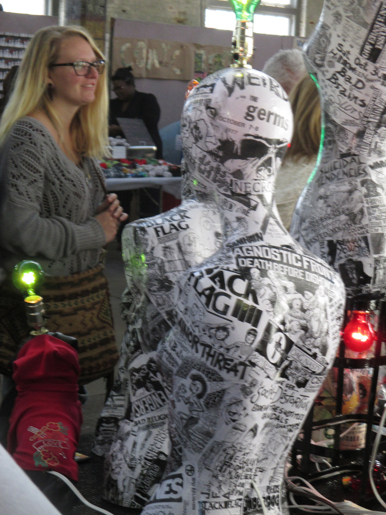 Lamps made from repurposed punk rock imagery and logos at a vendor stall.