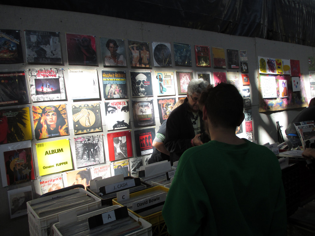 A wider view of a vendor stall with numerous crates of vinyl records for sale.