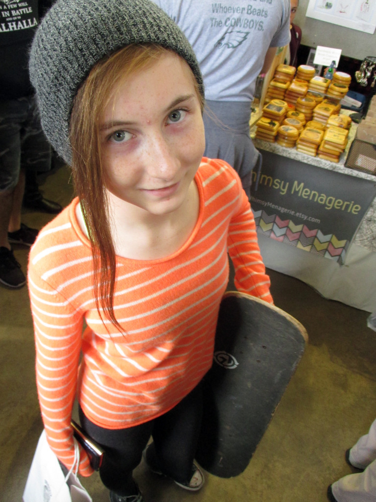 The author's daughter holding a skateboard purchased at the flea market.